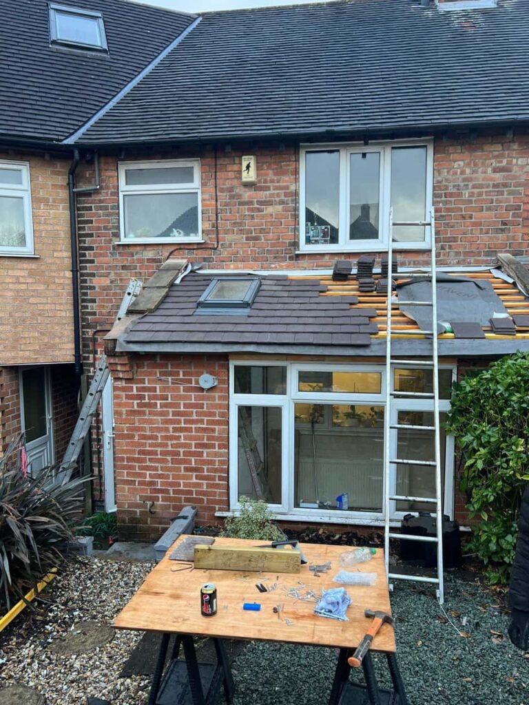 This is a photo of a roof extension that is having new roof tiles installed. This is a photo taken from the roof ridge looking down a tiled pitched roof on to a flat roof. Works carried out by Brierley Hill Roofing Repairs